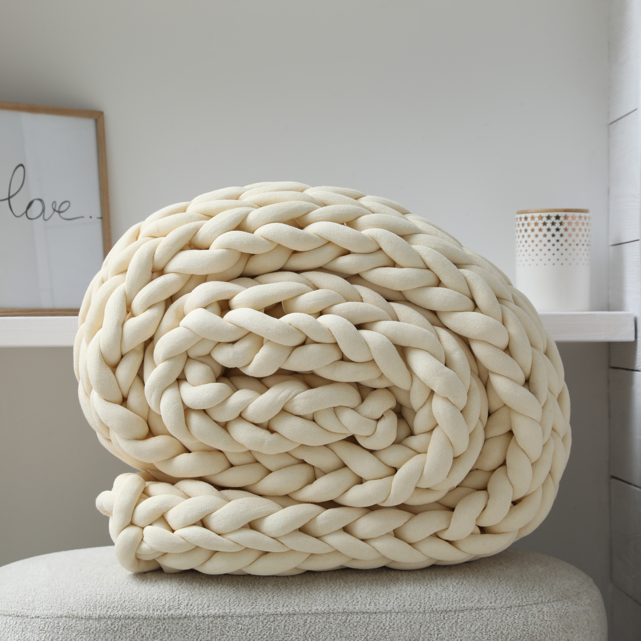 Rolled Up Chunky Blanket in Off White for Fragrance Ad Front View with White Decor in Back